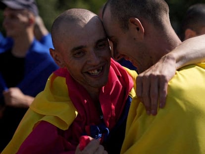 Two Ukrainian prisoners of war hug each other after being released by Russia at an unidentified location in August 2024.