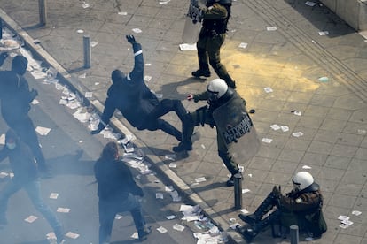 Un agente golpea a un manifestante en Atenas durante la protesta.