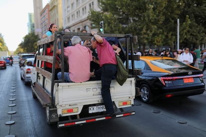 Un grupo de personas viaja en la parte trasera de un vehículo en Santiago tras las afecciones provocadas por el gran apagón.