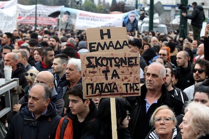 "Grecia mata a sus propios hijos" es el cartel que sostiene un manifestante durante la marcha, este viernes.