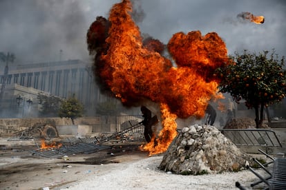 Manifestantes, junto a una columna de fuego frente al Parlamento.