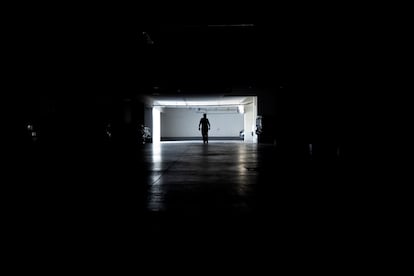 Un hombre camina en un estacionamiento durante un corte de energía, este martes en Santiago.