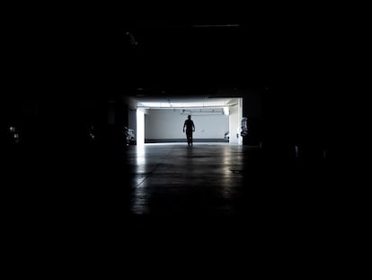 Un hombre camina en un estacionamiento durante un corte de energía, este martes en Santiago.