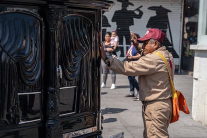 Un hombre se acerca a la carroza fúnebre que lleva los restos de la cantante.