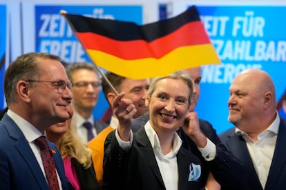 La líder del partido ultraderechista AfD, Alice Weidel, ondea una bandera alemana en la sede del partido  en Berlín.