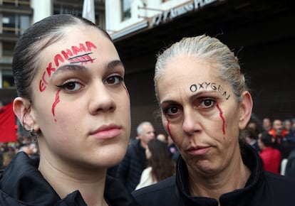 Dos manifestantes asisten a la protesta con los lemas pintados en sus rostros, a la izquierda, "Crimen" y "Oxígeno".