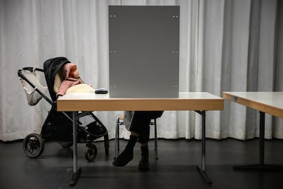 Una mujer vota junto a su bebé en un colegio electoral en Berlín, este domingo.