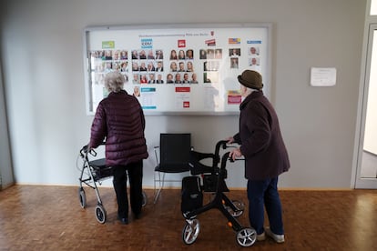 Dos votantes observan varios carteles con los candidatos electorales, este domingo en un centro de votaciones de Berlín.