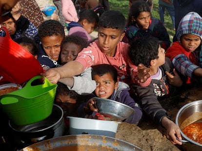 Palestinian children wait for a food ration in Khan Yunis, southern Gaza, on Monday.