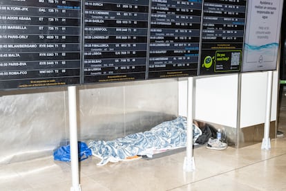 Una persona descansa en el suelo del aeropuerto Adolfo Suárez Madrid Barajas.