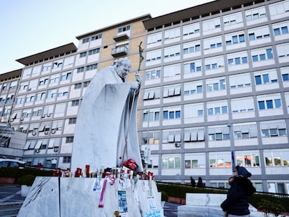 Una mujer junto a la estatua de Juan Pablo II situada en el exterior del hospital Gemelli de Roma. este martes.