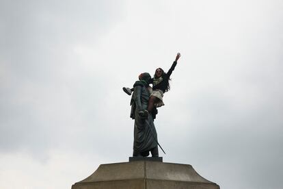 Una mujer sube a la estatua de Simón Bolívar durante la marcha que conmemora el Día Internacional de la Mujer en Bogotá, Colombia.