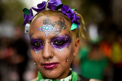 Una mujer marcha en Buenos Aires con el rostro pintado con los colores que enmarcan la lucha feminista en el mundo.