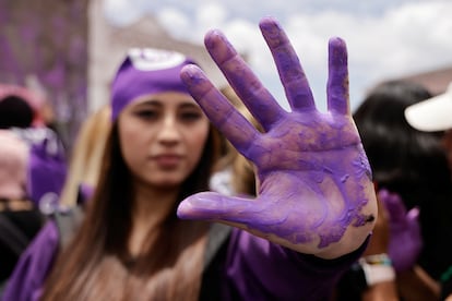 Una mujer participante de la marcha en Quito, Ecuador, muestra su mano morada. El color morado es un símbolo contra la violencia machista.