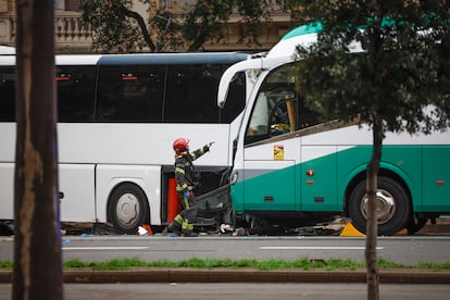 Un bombero al lado de los dos autobuses accidentados