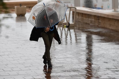 Una persona se resguarda con un paraguas de la lluvia que cae en Almería, este jueves.