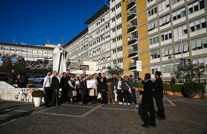 Un grupo de fieles se hace una foto ante la estatua de Juan Pablo II, frente al hospital Gemelli de Roma, donde está ingresado el papa Francisco, este lunes.