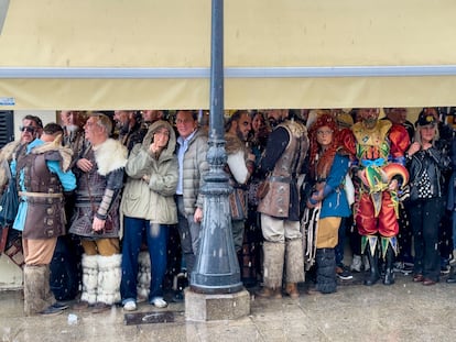 Público e integrantes de las agrupaciones del Carnaval se resguardan de la lluvia, este domingo en Cádiz.