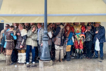 Un grupo de personas se resguarda de la lluvia en Cádiz, que celebraba el Carnaval este domingo.