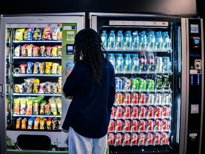 Una joven contempla dos máquinas de ‘vending’ llenas de bebidas azucaradas y energéticas, este lunes.