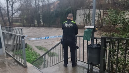 Un policía local de Ripoll corta los accesos al cauce del Ter en la población, este domingo.