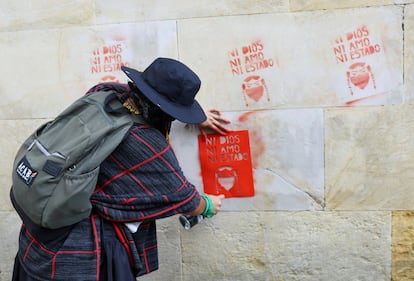 Una mujer realiza pintas en las calles de Bogotá.