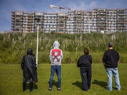 cgdi2barbrcbfoxg6dueoqfoui Cuatro cooperativistas del proyecto de alquiler social, ante una de las parcelas del barrio coruñés de Xuxán donde se deberían estar construyendo los edificios.