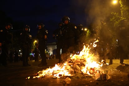 phomgrwy4o4ve744jpjivbe2t4 Los policías en París cerca del fuego provocado por los aficionados.