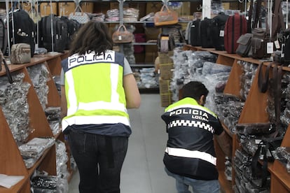 Dos agentes de Policía clasifican productos falsificados en Málaga.