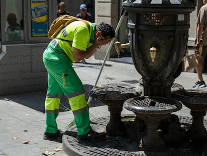 Un trabajador de la limpieza se refresca en una fuente en Barcelona, este viernes.